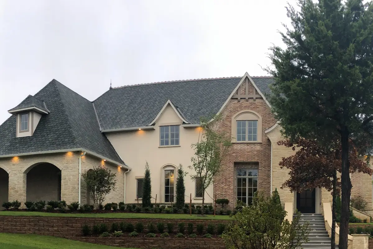 Stone and brick custom home exterior with landscaped front yard